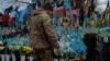 A soldier leaves two cigarettes next to a photo of his fallen comrade on Independence Square in Kyiv on February 3.