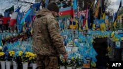 A soldier leaves two cigarettes next to a photo of his fallen comrade on Independence Square in Kyiv on February 3.