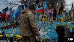 Një ushtar ukrainas pranë një memoriali për ushtarët e rënë ukrainas dhe ushtarët e huaj. Kiev, 3 shkurt 2025. 