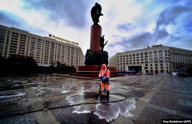 Një punëtor komunal dezinfekton një shesh pranë monumentit të Leninit në qendër të Moskës.(AFP/Yuri Kadobnov)