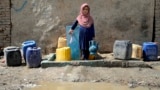 An Afghan child collects water from a public water pump in Kabul (file photo)