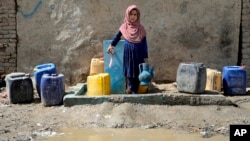 An Afghan child collects water from a public water pump in Kabul (file photo)