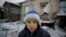 Мальчик на фоне разрушенного в результате обстрелов дома. Авдеевка, 2 февраля 2017 года