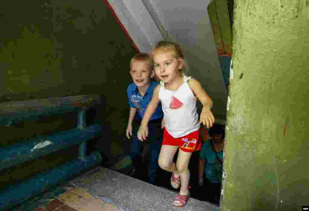 Local children Ulyana and Sergei leave a bomb shelter which they are using as living quarters after their homes were destroyed in shelling not far from the front line in Donetsk, eastern Ukraine. (epa/Alexander Ermochenko)