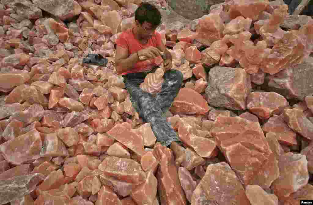 A man in Lahore applies the final touches to a sculpture made from rock salt.&nbsp;