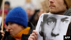 Egy férfi Alekszej Navalnij fényképét tartja egy megemlékezésen 2024. február 18-án a berlini orosz nagykövetség előtt, miután a Kreml legjelentősebb kritikusa egy sarkvidéki börtönben meghalt