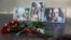 Photographs of journalists Orkhan Dzhemal (right), Kirill Radchenko (center) and Aleksandr Rastorguyev are seen at a small memorial to the slain jounalists outside the Central House of Journalists in Moscow.