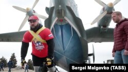 Спортсмен Джамшид Исматиллаев (слева) во время буксировки противолодочного самолета-амфибии Бе-12 весом 31,5 тонн на аэродроме в Севастополе