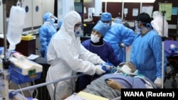 Emergency medical staff and nurses wearing protective suits, help while transferring a patient with coronavirus (COVID-19) to Masih Daneshvari Hospital, in Tehran, March 30, 2020