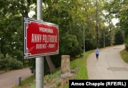 A woman jogs along Anna Politkovskaya Promenade. The Russian embassy fence is just to the right of this image.
