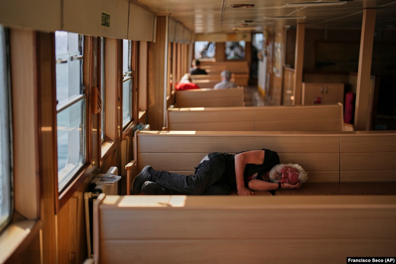 Një burrë duke fjetur në një traget, më 23 maj 2025.