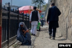An Afghan woman begs for alms in Kabul on September 23.