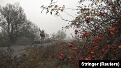 Ілюстраційне фото. Поліцейський цілиться з гвинтівки під час загрози удару російського FPV, на шляху до евакуації цивільних із прифронтового міста Гуляйполе. Запорізька область, Україна, 14 листопада 2025 року