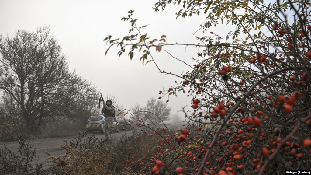 Полицейский целится из винтовки во время угрозы удара российского FPV на пути к эвакуации гражданских из Гуляйполя, Запорожская область, ноябрь 2025 года
