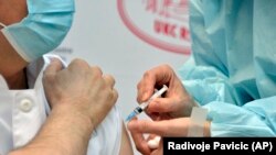 Медицина қызметкері ер адамға коронавирусқа қарсы вакцина салып жатыр. Көрнекі сурет.