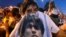 People mourn soccer legend Diego Maradona outside the morgue