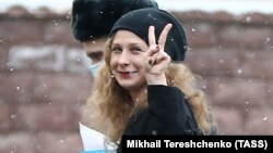 Maria Alyokhina flashes a V-sign as she arrives to attend a court hearing in Moscow in March.