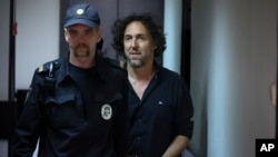 French citizen Laurent Vinatier (right) is escorted into a cage in a courtroom in the Zamoskvorechye district court in Moscow on June 7.