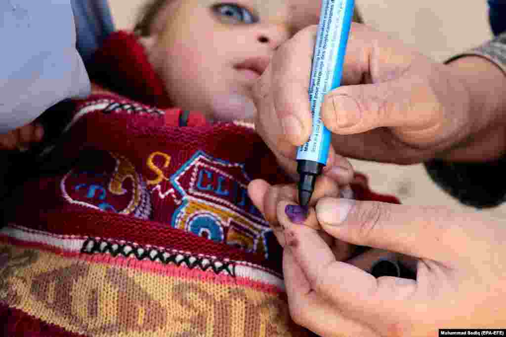 Një punëtor shëndetësor në Kandahar, shënjon gishtin e një fëmije afgan, përpara se atij t&rsquo;i administrohet vaksina kundër polios më 26 janar. (efe-EPA/Muhammad Sadiq)