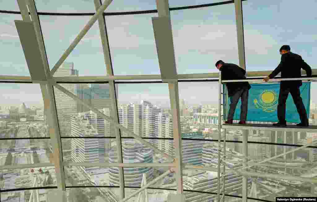 Employees attach a Kazakh state flag inside the Baiterek monument in central Nur-Sultan. (Reuters/Valentyn Ogirenko)