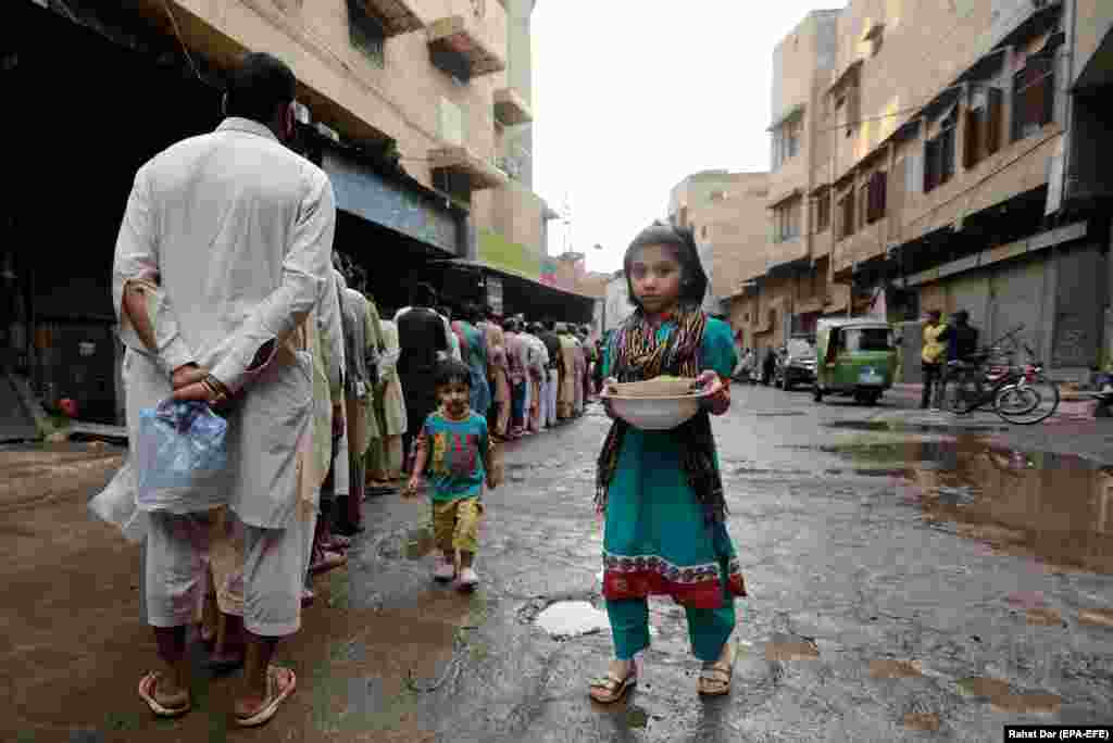 People line up to receive free food as the time to break fast approaches during the Muslim holy month of Ramadan amid a coronavirus lockdown in Lahore, Pakistan. (epa-EFE/Rahat Dar)