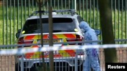 A police forensics investigator approaches a crime scene where one man was killed in Woolwich in southeast London.