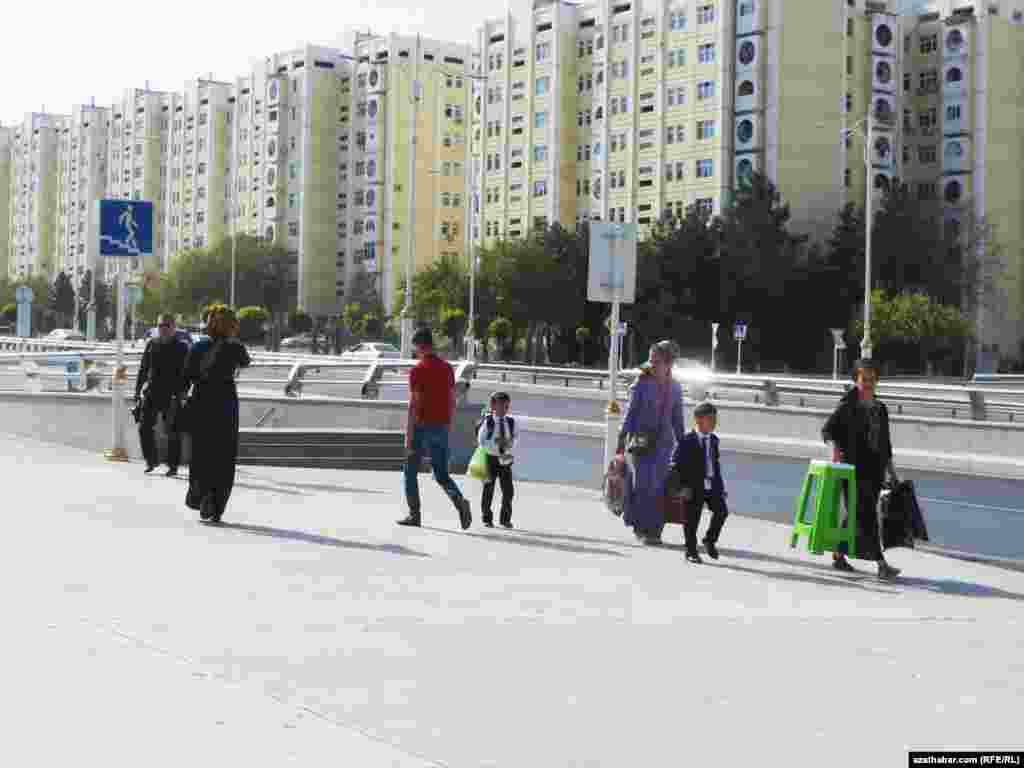 Aşgabadyň köçeleriniň birinden barýan raýatlar.