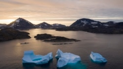 Iceberguri de mari dimensiuni plutind la răsăritul soarelui lângă Kulusuk, Groenlanda, la 16 august 2019. 