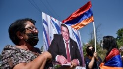 Armenia -- A supporter of Armenian opposition leader Gagik Tsarukian holds its portrait during a unauthorised rally close to National secuirury service headquarter in Yerevan, June 14, 2020