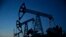 Pump jacks are seen at LUKoil's Imilorskoye oil field. Falling oil prices and revenues are endangering Russia's credit rating.