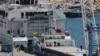 Policajac koristi psa tragača da pregleda teretni brod natovaren humanitarnom pomoći za Gazu, u luci Larnaka, Kipar, 16. marta 2024. 