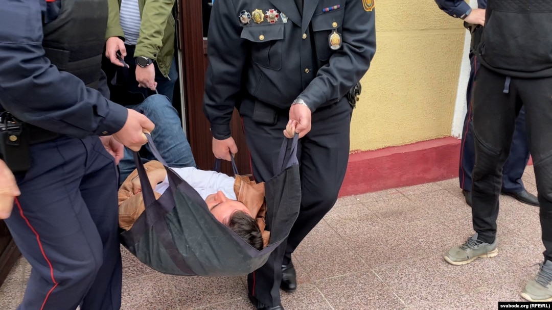 Stsyapan Latypau is carried out of the courtroom after stabbing himself in the neck.