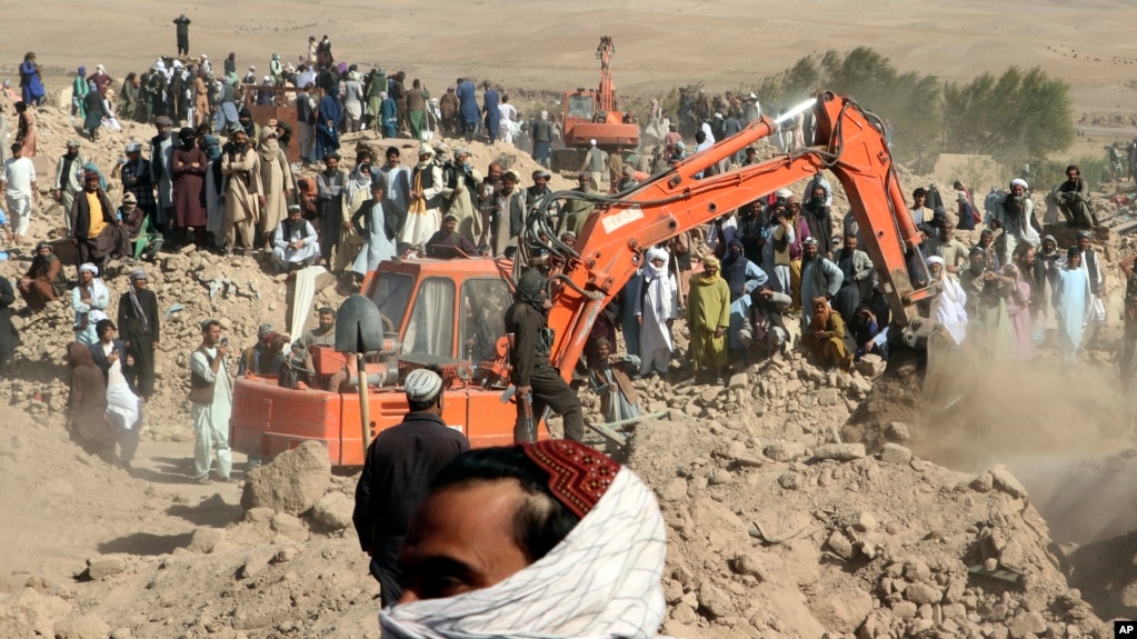 An excavator removes mud from a collapsed house amid the search for victims after an earthquake in the Zindah Jan district of Herat Province in western Afghanistan. 