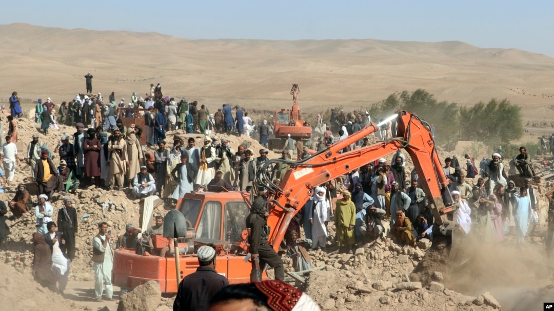 Un excavator sapă printre ruinele unei case preăbușite în districtul Zenda Jan din provincia Herat, din vestul Afganistanului, duminică, 8 octombrie 2023.