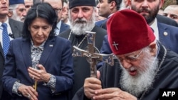 Президент Грузии Саломе Зурабишвили (слева) и патриарх Грузинской православной церкви Илия II (справа) принимают участие в молитве, посвященной 30-й годовщине «Тбилисской трагедии», в рамках празднования Дня национального единства в Тбилиси 9 апреля 2019 год.