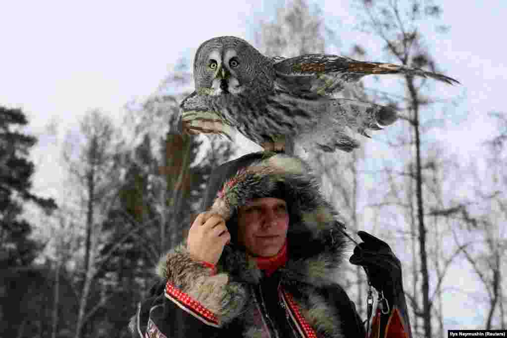 A great gray owl sits on the head of ornithologist Daria Koshcheyeva in the Siberian taiga forest in Krasnoyarsk, Russia. (Reuters/Ilya Naymushin)