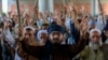 Supporters of Tehrik-e Labaik Pakistan (TLP) gather on a blocked street to protest against the arrest of their leader after he demanded the expulsion of the French ambassador over depictions of Prophet Muhammad, in Peshawar, on April 13.