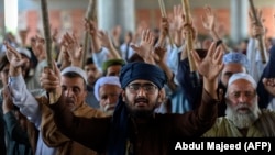 Supporters of Tehrik-e Labaik Pakistan (TLP) gather on a blocked street to protest against the arrest of their leader after he demanded the expulsion of the French ambassador over depictions of Prophet Muhammad, in Peshawar, on April 13.