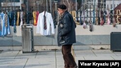 Një burrë kalon pranë qindra kravatave dhe këmishave të vendosura nga qytetarët në rrethojën e ndërtesës së Qeverisë, më 26 dhjetor 2017, në shenjë proteste ndaj vendimit për rritje pagash nga ana e Kryeminsitrit për vete dhe kabinetin e tij - vendim i cili u pezullua përkohësisht.