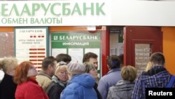 People line up to buy foreign currency outside a bank's exchange office in Minsk on April 6.