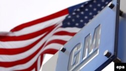 General Motors логотипи ва АҚШ байроғи.