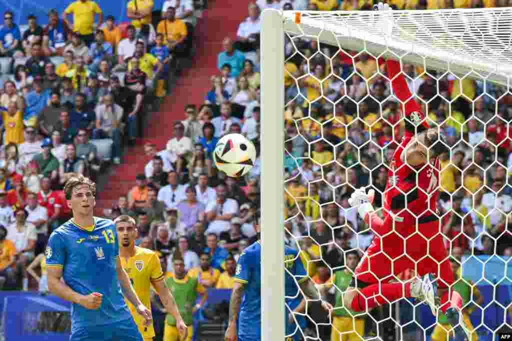 Portarul echipei naționale a Ucrainei, Andrii Lunin, privește cum balonul se îndreaptă spre bara porții sale în timpul meciului dintre România și Ucraina.&nbsp;