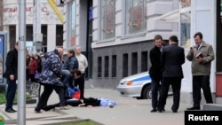 Investigators inspect the body of one of several victims killed by a gunman in Belgorod, Russia on April 22. 