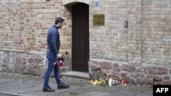 Чалавек прынёс кветкі да дзьверы сынагогі ў Гальле на наступны дзень пасьля страляніны