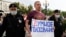 Russian police detain an opposition activist who is holding a poster reading "Smart Voting" in Moscow on August 14.