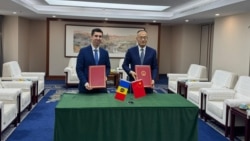 Ministrul moldovean de Externe, Mihai Popșoi, făcând schimb de note, la Beijing, cu Chen Xiaodong, președintele Agenției pentru Dezvoltare și Cooperare Internațională a Republicii Populare Chineze 