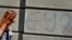 A woman in downtown Belgrade walks past graffiti that says "EU?"