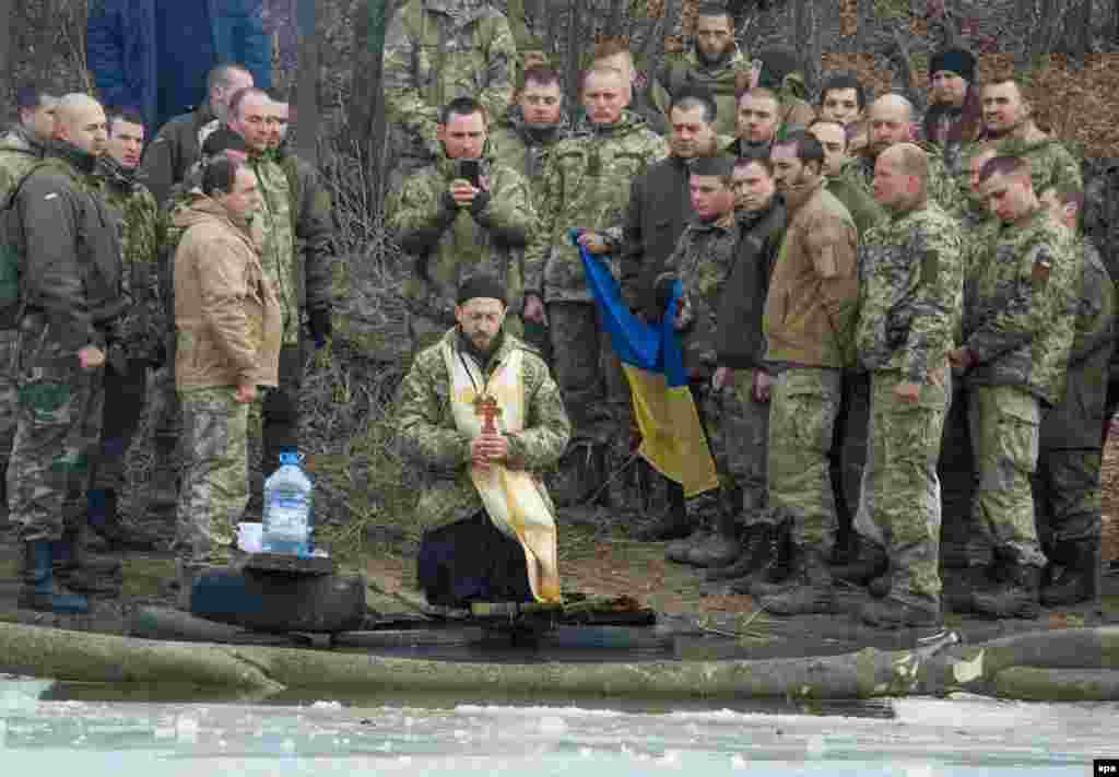 Військовий капелан благословляє воду під час святкування Водохреща у селі Лебединське, недалеко від Маріуполя, 19 січня 2017 року ПЕРЕГЛЯНЬТЕ ФОТОГАЛЕРЕЮ: Як кияни купалися на Водохреще