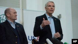 U.S. Senators Chris Coons (left) and Rob Portman talk to the media during their visit to a distribution center of the United States Agency for International Development in Kyiv on November 3.
