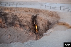 An isolated flame at the Darvaza gas crater photographed in June